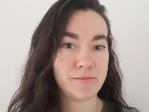 Man in festive hat drinking from a bottle and giving a thumbs up.